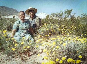 Grandparents Lettie and Fenton Whitney sitting among desert flowers